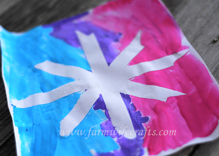 A simple craft to make with your toddler this winter are these snowflake paintings with masking tape.